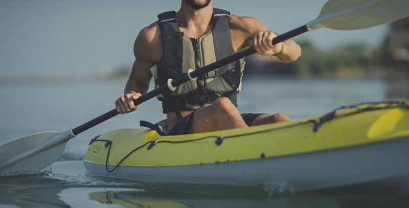 Cropped unrecognisable Caucasian man kayaker paddling on the river.